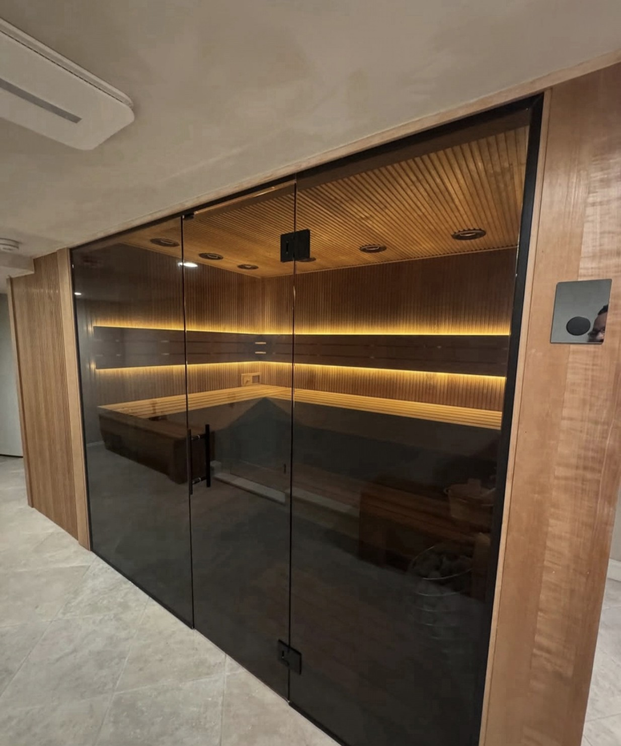Main finished view with warm concealed lighting and the full smoked-glass facade.