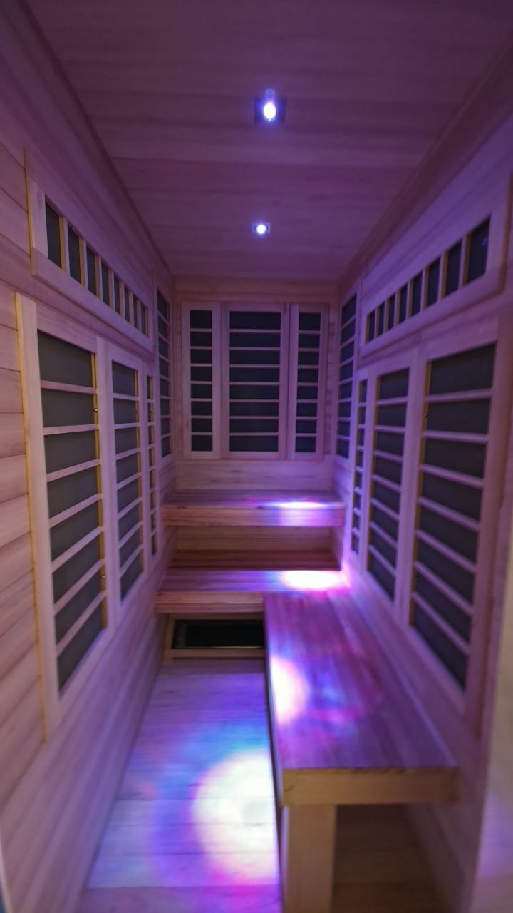 Installed infrared sauna interior with wood benches and color lighting