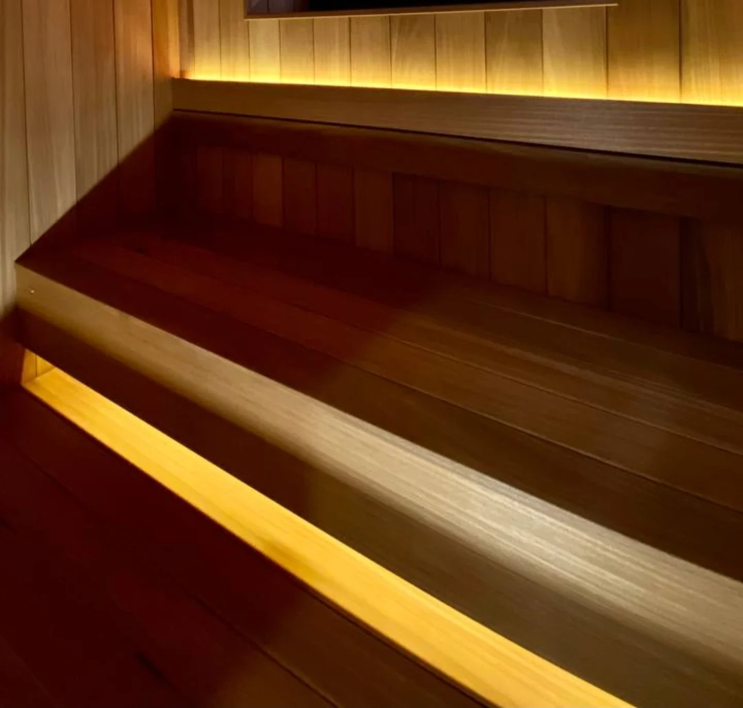 Warm-lit wood benches beneath a high horizontal window