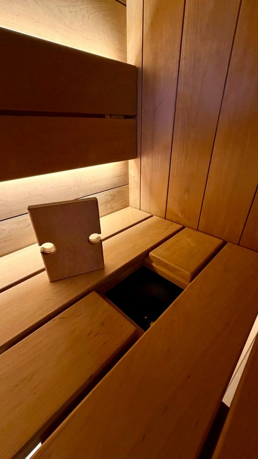 Removable wood bench section lifted to reveal concealed technical access