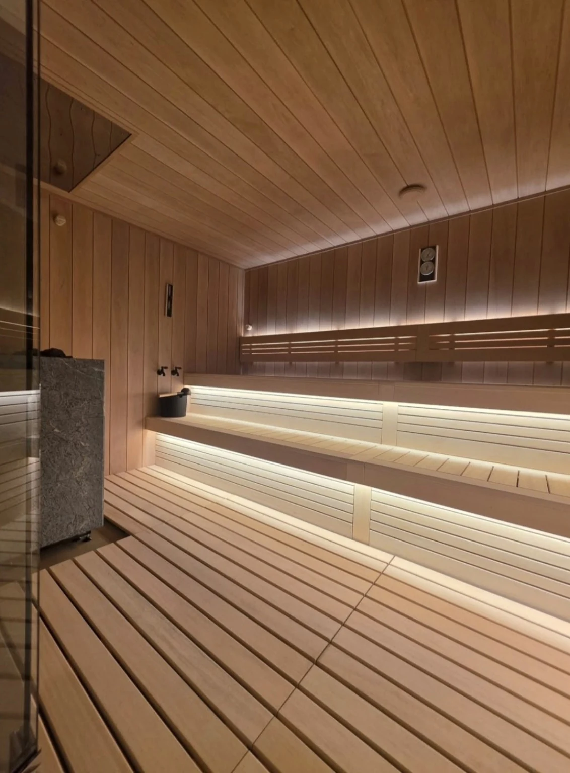 Interior view of wide wood benches, slatted fronts and warm integrated lighting