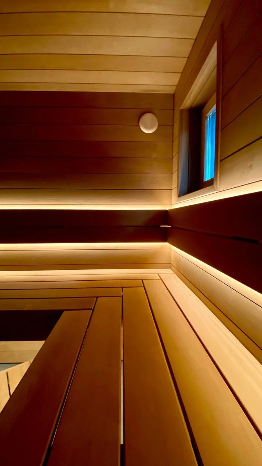 Custom bench joinery beneath illuminated backrests