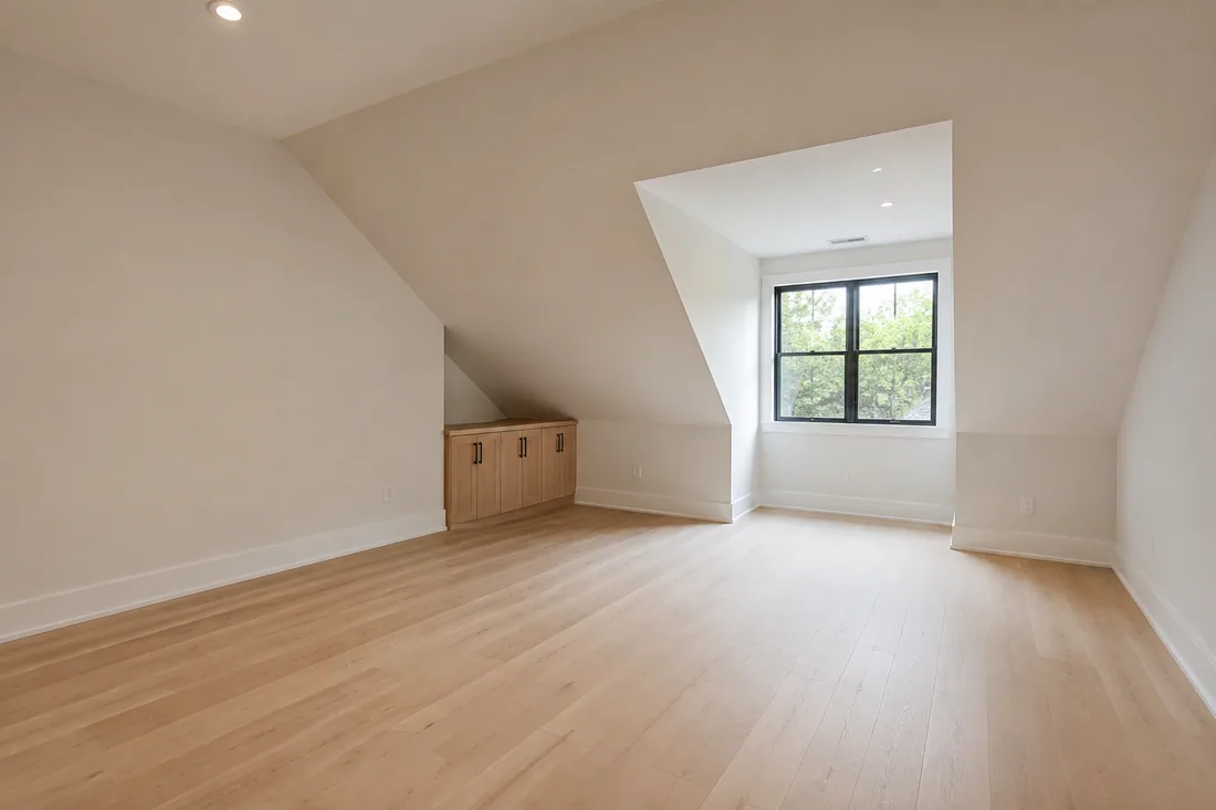 Unused upstairs bonus room with a sloped ceiling and dormer window